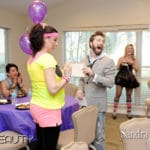 2 women and a man dressed in 80's outfits laughing at an event
