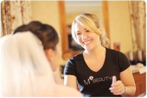 M3 Beauty team member applying makeup to a bride's face
