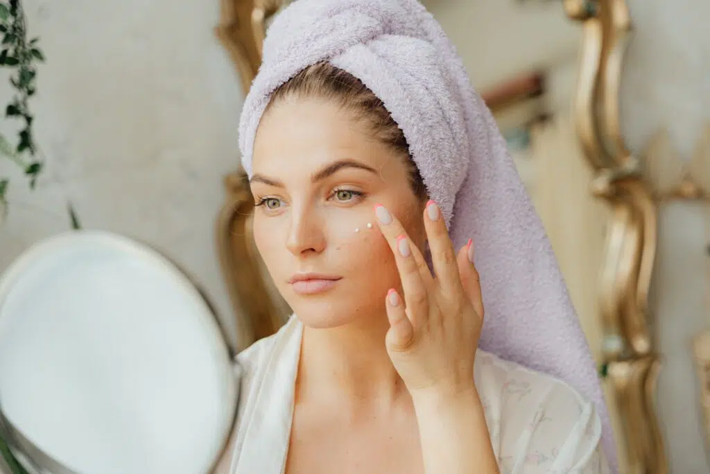 woman applying cream to face