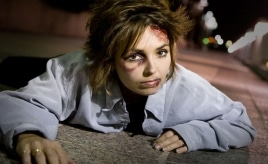 woman on the floor with makeup showing bruises and blood