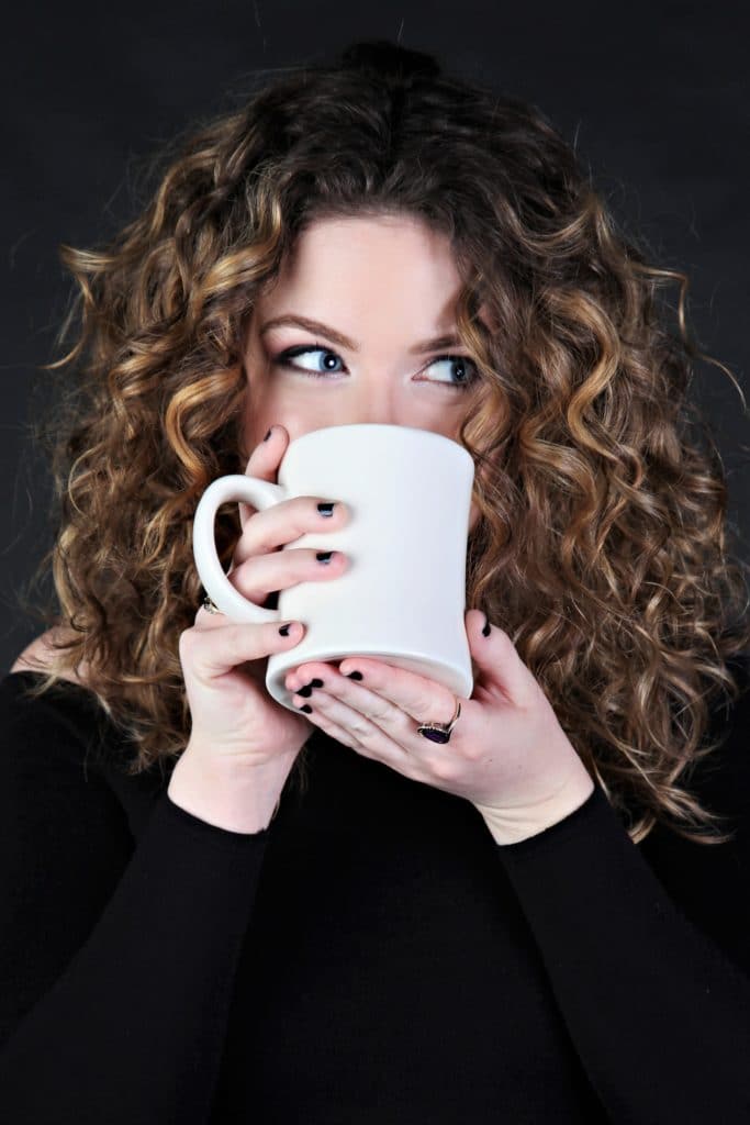 Professional headshot of woman drinking coffee