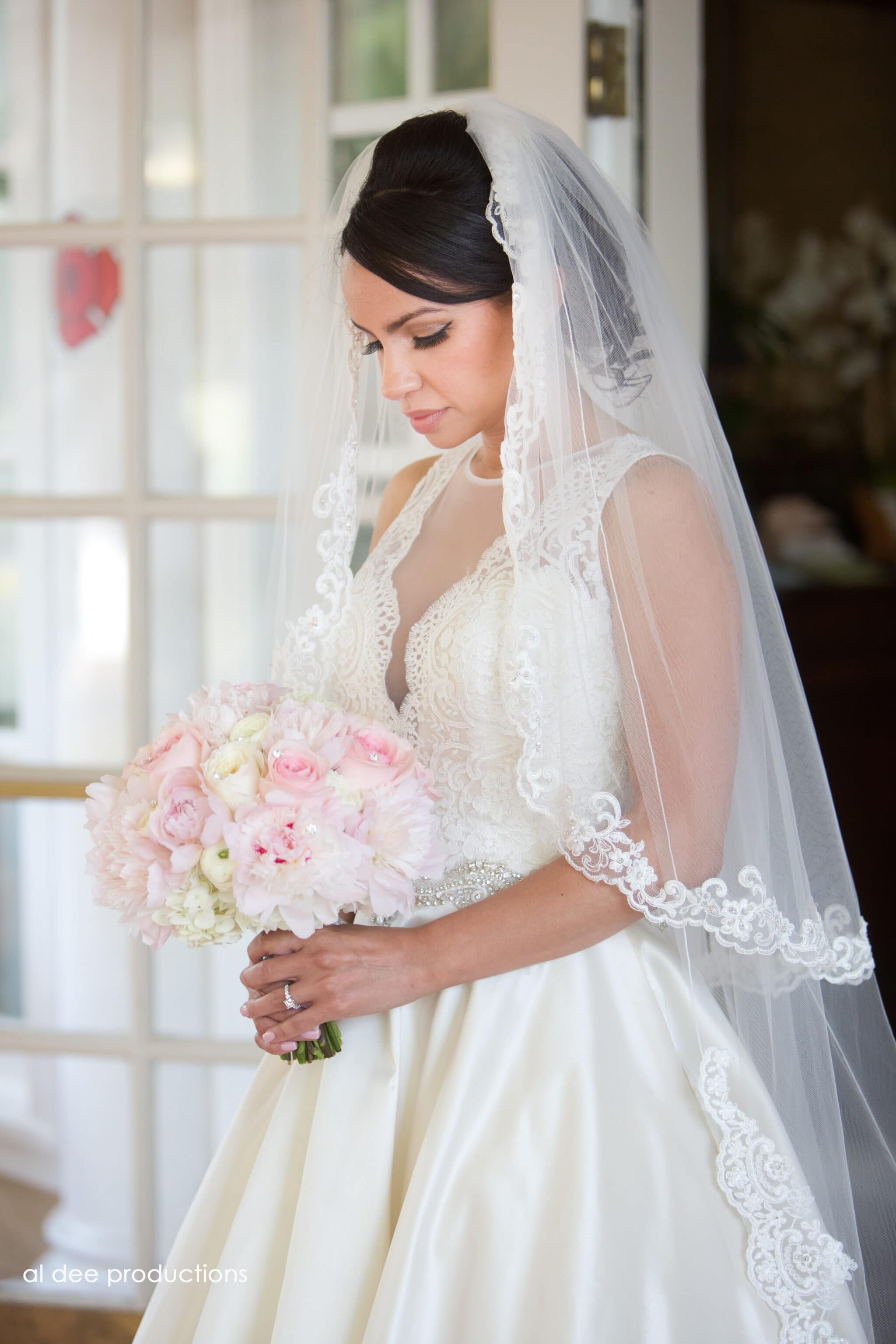 Beautiful bride looking down at her pink bouquet