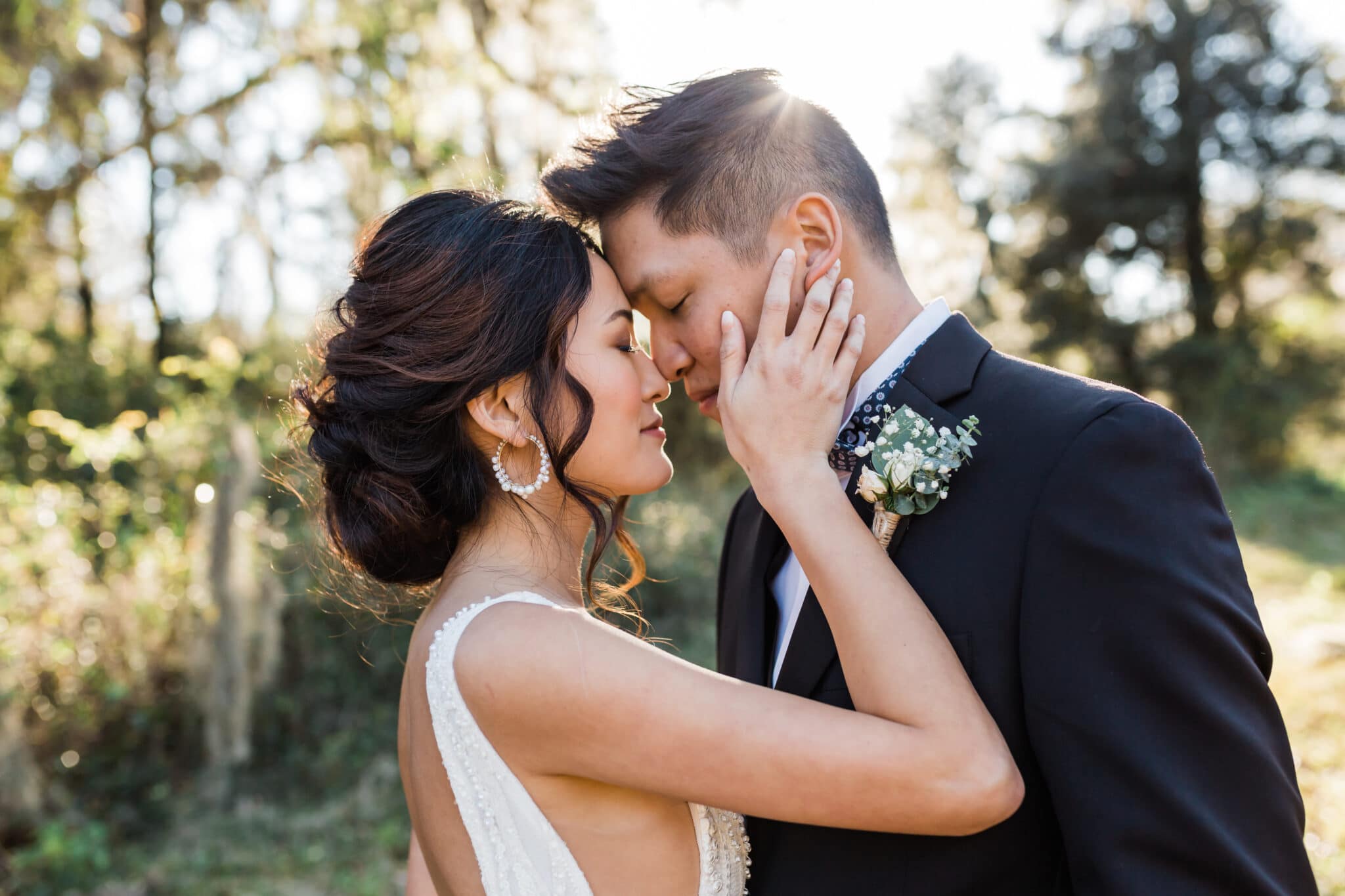 Bride and groom with their foreheads together at sunset