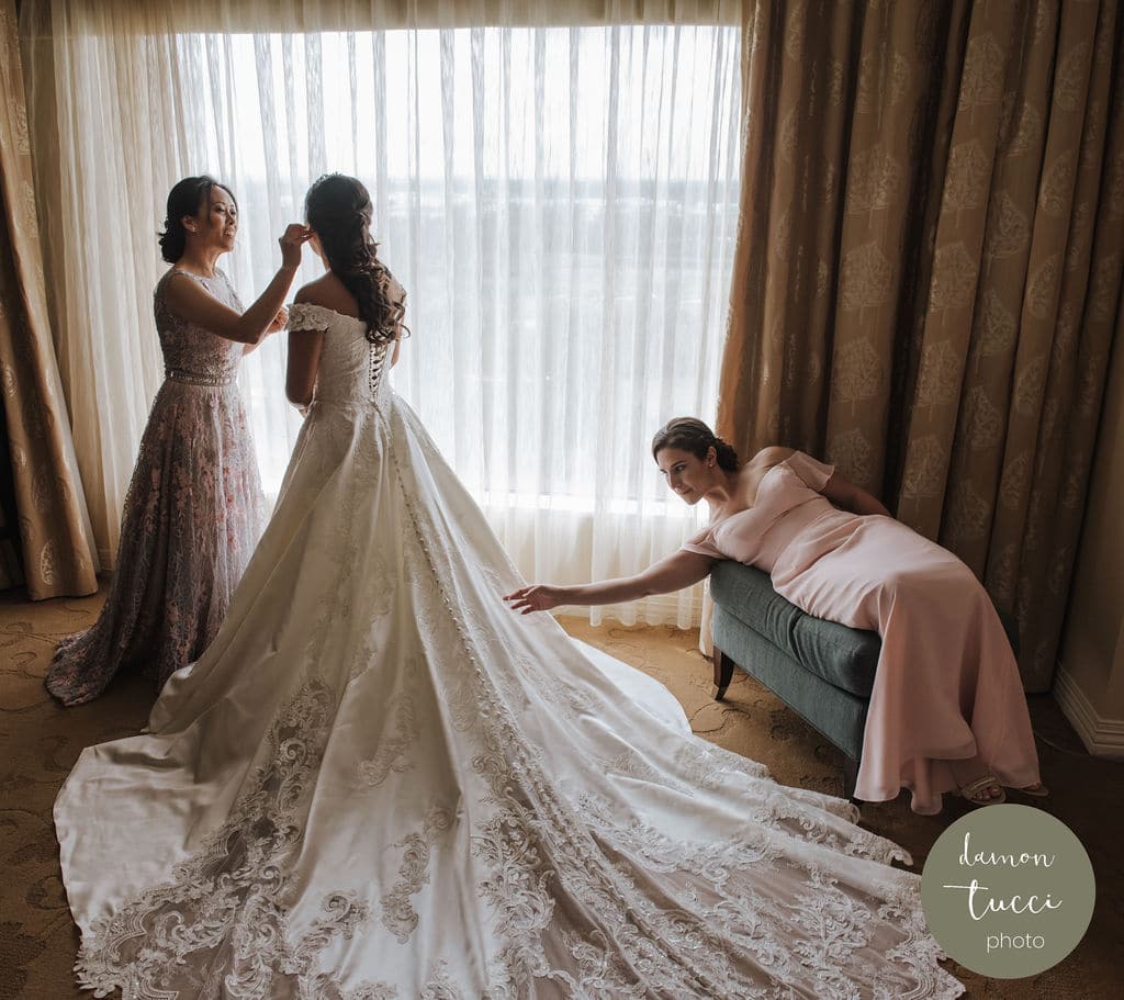 Bride getting ready with help of bridesmaids