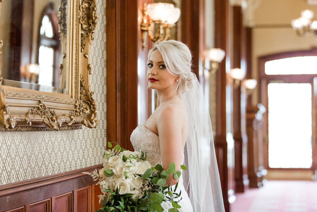 Bride looking at camera holding white flowers
