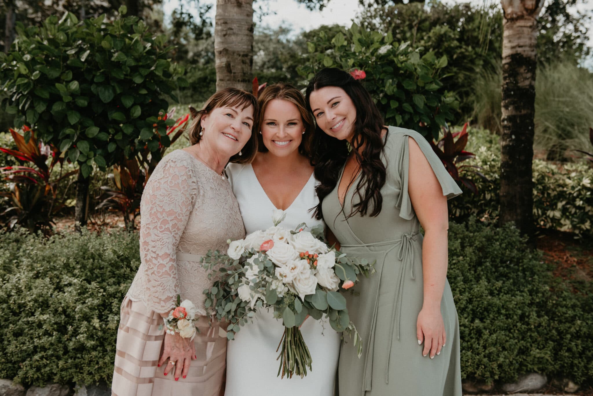 Bride posing with her mother and bridesmaid