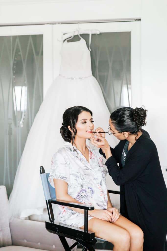 Woman having her makeup done on wedding day
