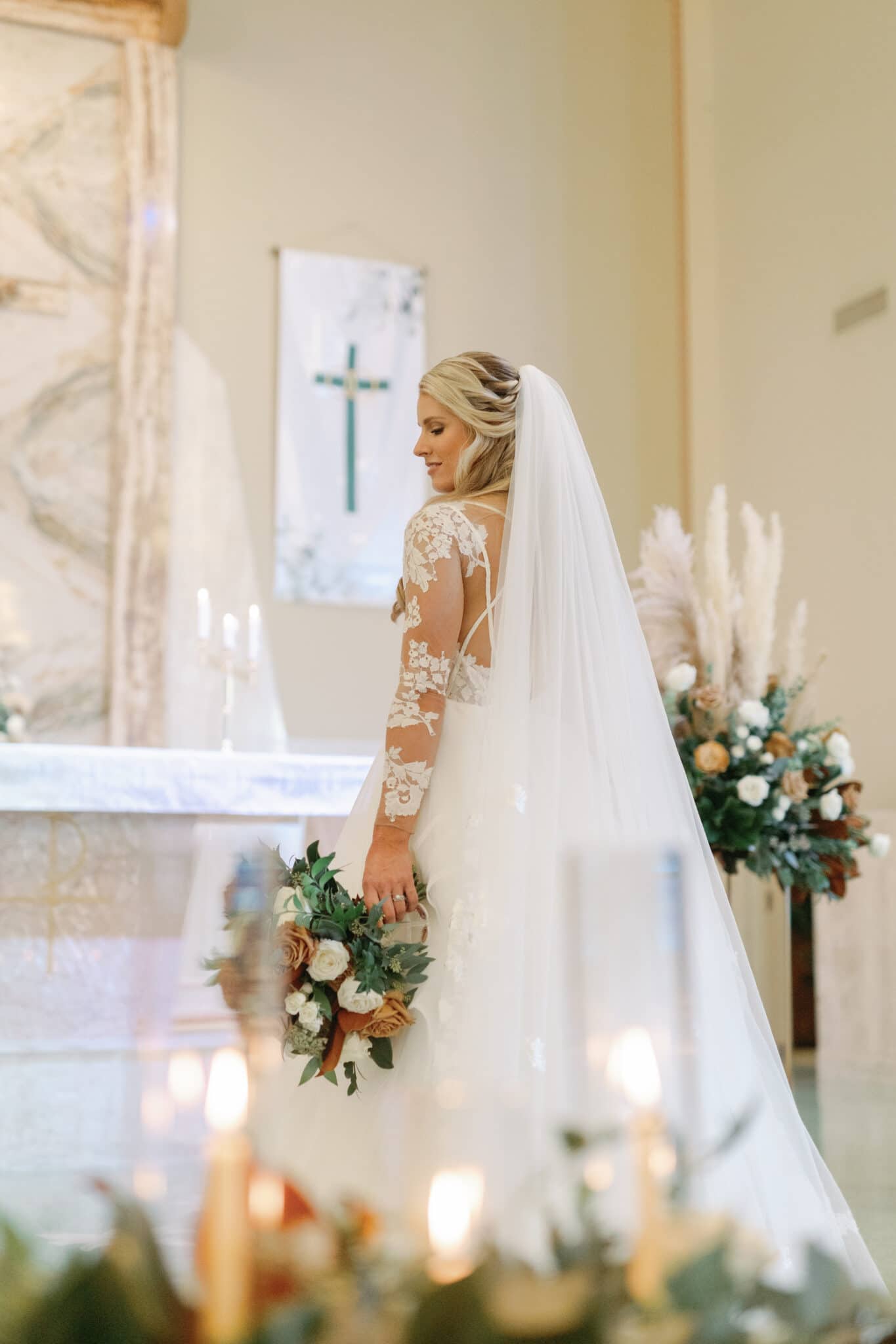 Bride poses with her bouquet in chapel