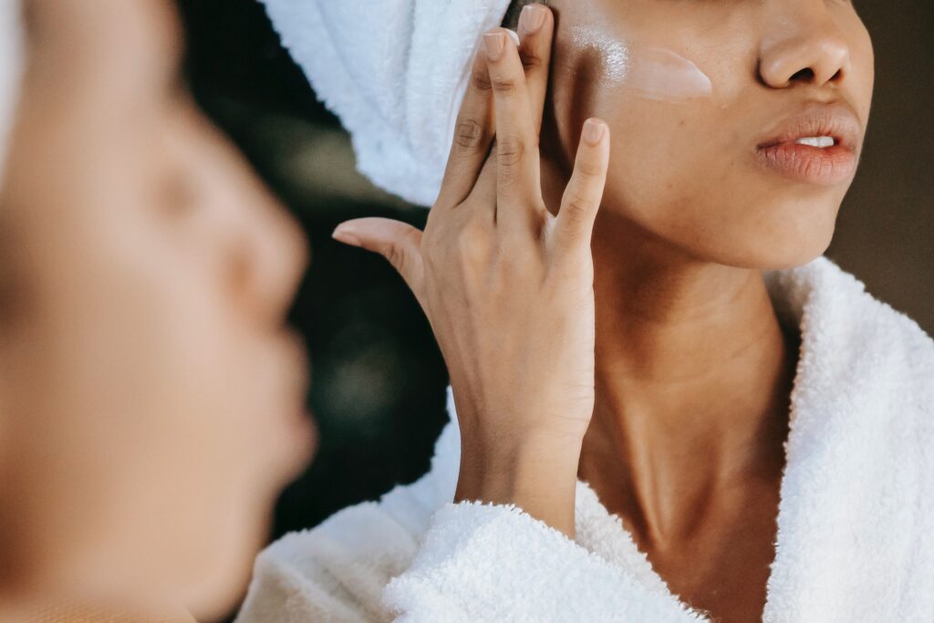 woman applying moisturizer to face