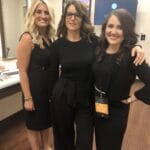 2 women standing with Tina Fey after they applied her makeup