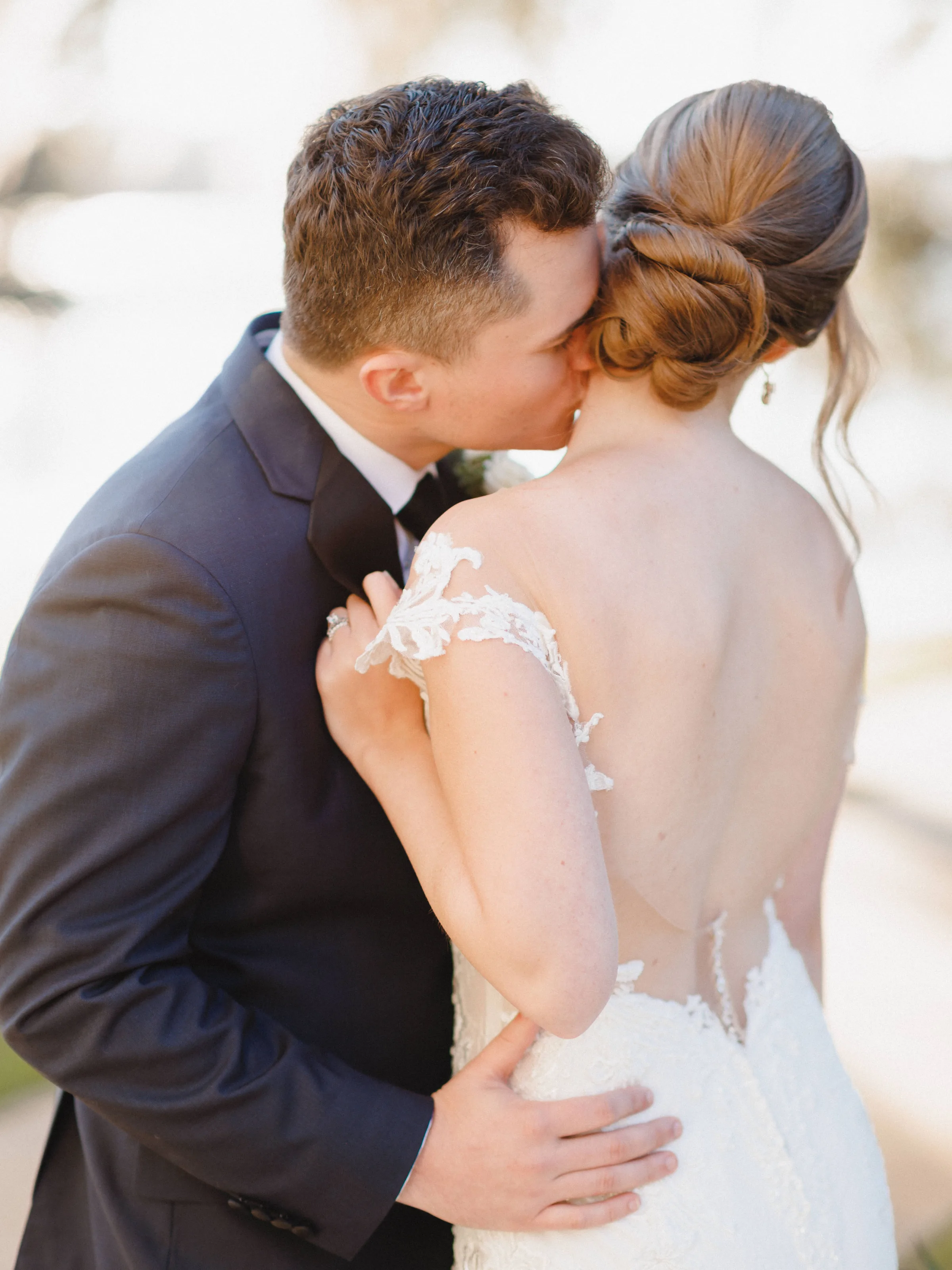 bridal updo hairstyle m3 beauty orlando wedding - Wedding Makeup and Hair Gallery Elegant bridal updo hairstyle with romantic low bun and face-framing pieces created by M3 Beauty for Orlando Florida wedding, bride embracing groom in navy suit